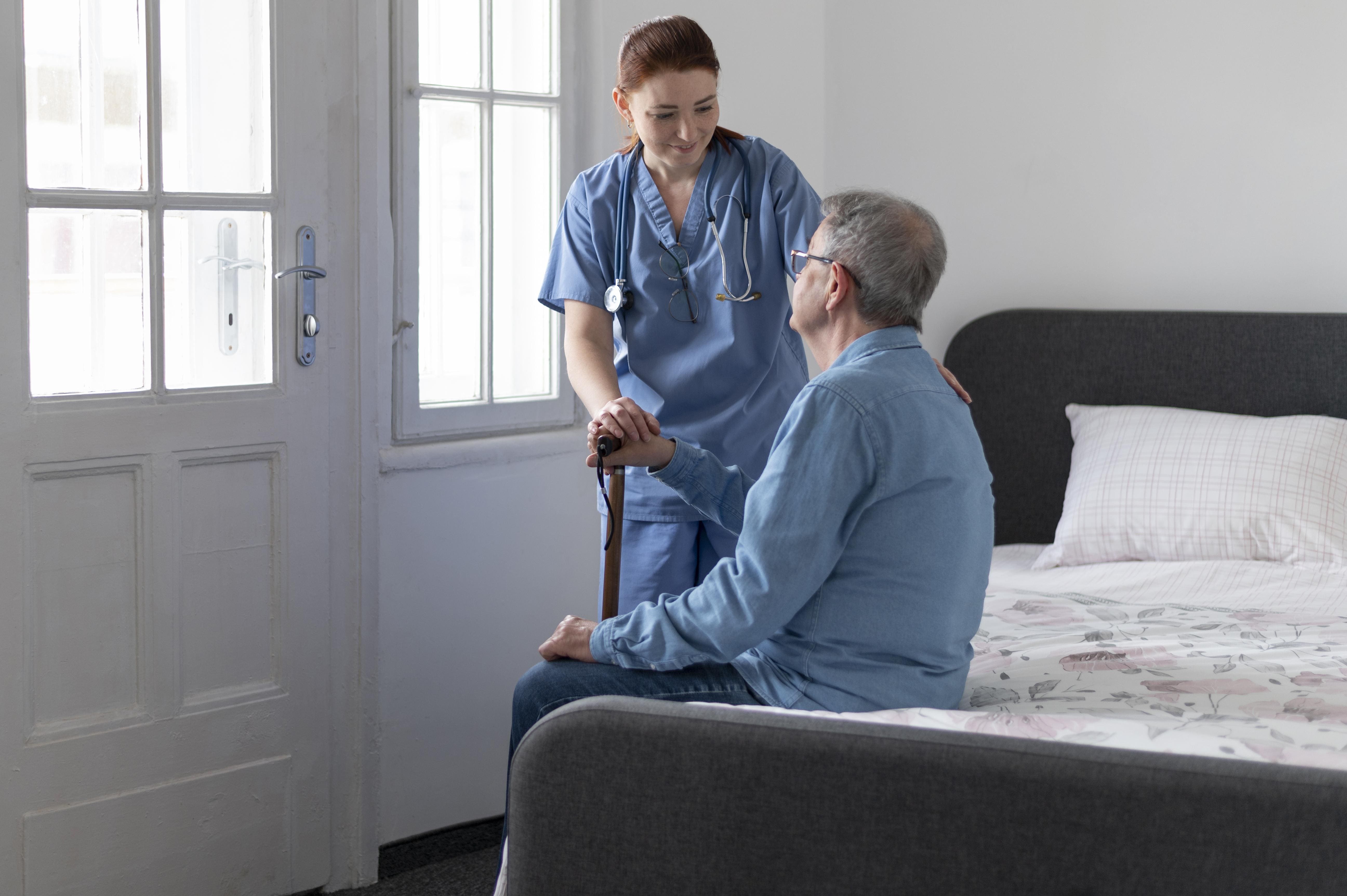 Médico a domicilio en Madrid asistiendo a un paciente mayor en su habitación con atención empática y profesional.