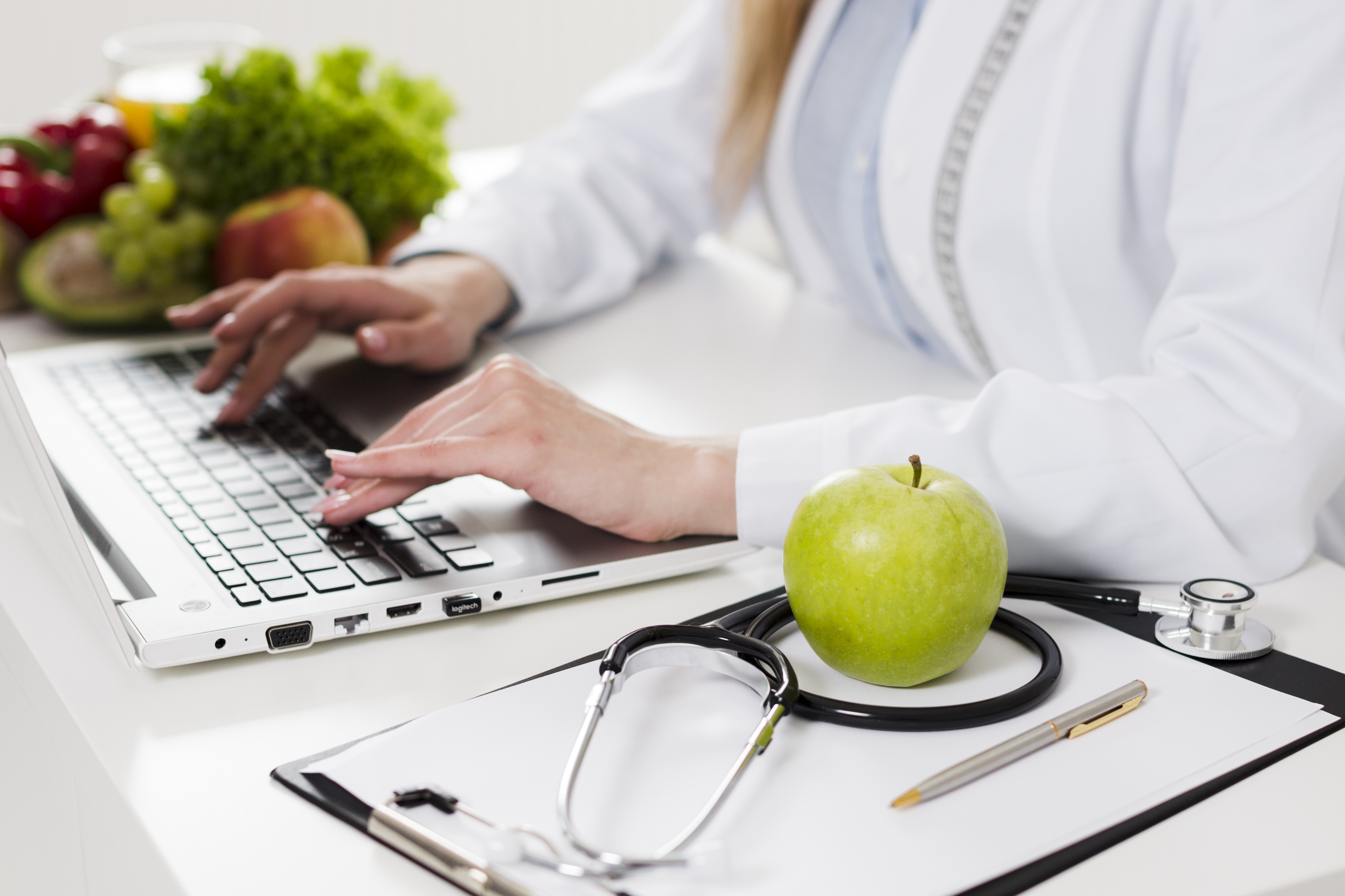 Nutricionista en Alcobendas en consulta profesional con ordenador y frutas saludables